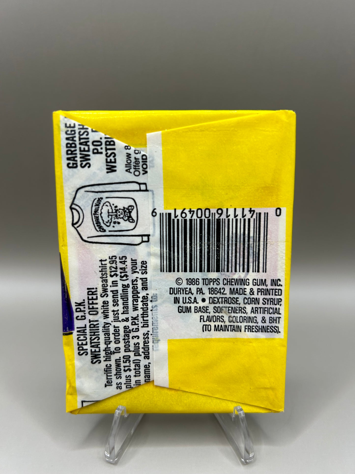 Back of a 1986 Garbage Pail Kids Series 3 unopened pack by Topps. The yellow packaging features a barcode, ingredients list, copyright information from Topps Chewing Gum, Inc