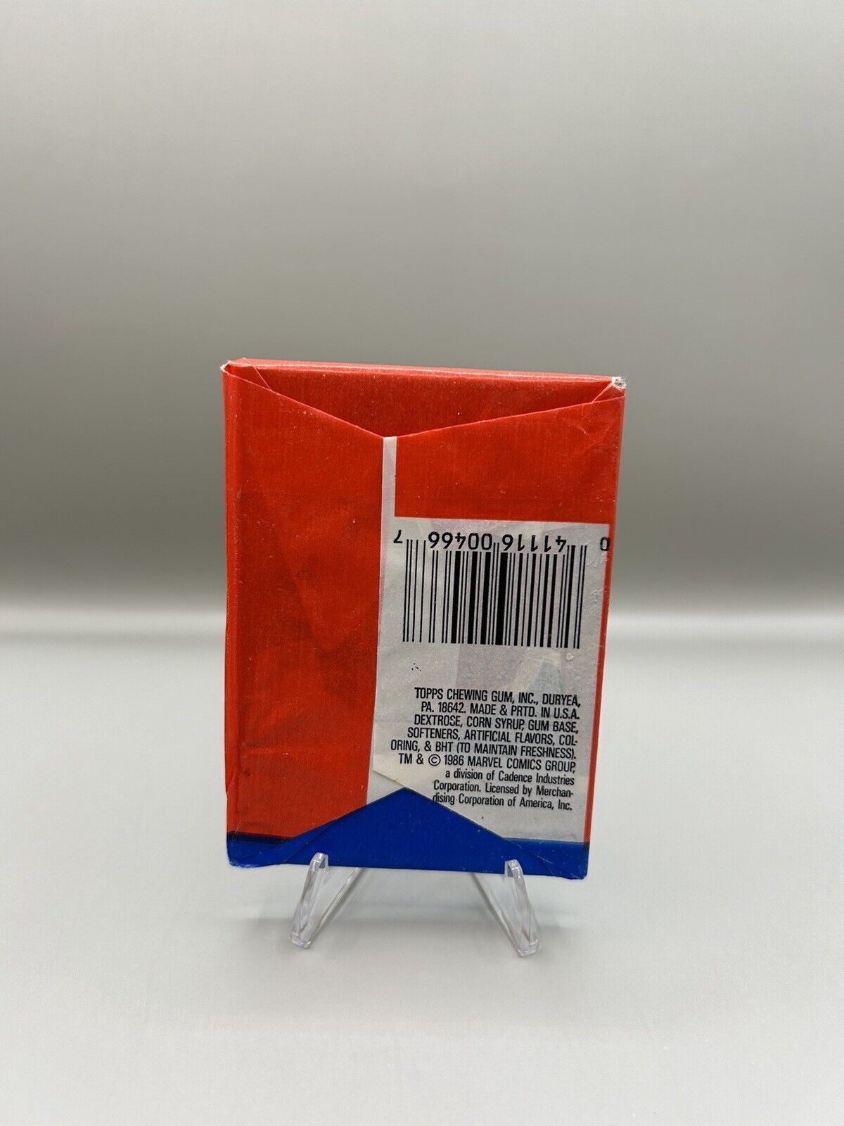 Back view of a 1986 sealed Topps Howard the Duck trading card pack showing product details and barcode, displayed on a stand