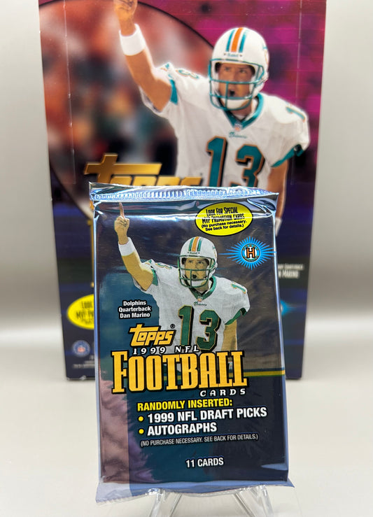 1999 Topps NFL Football trading card pack featuring Dan Marino on the cover. Includes 11 cards in a sealed pack.