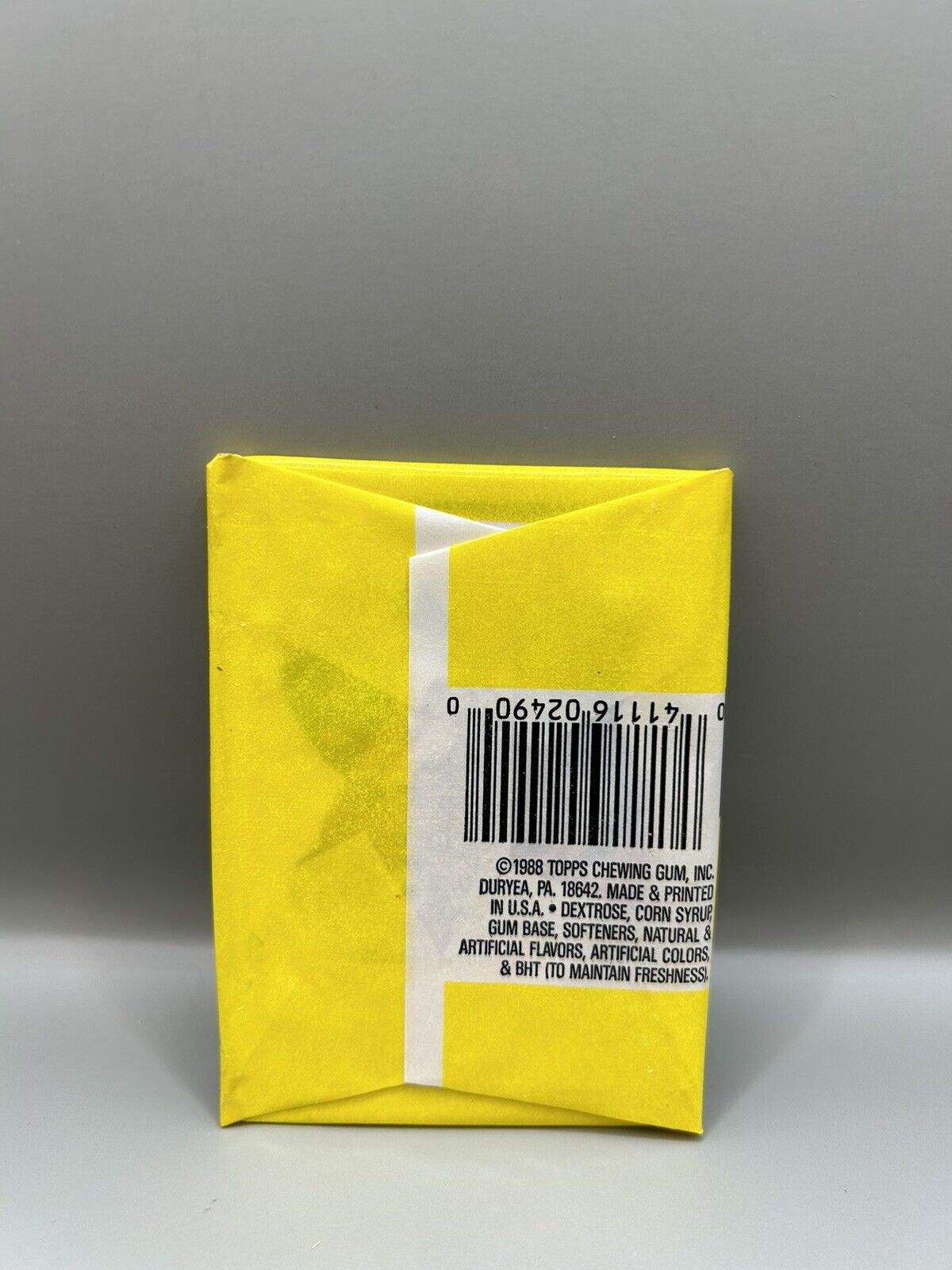 Back of a 1988 Garbage Pail Kids 12th Series unopened pack by Topps. The yellow packaging includes a barcode, ingredients list, and copyright information from Topps Chewing Gum, Inc.”